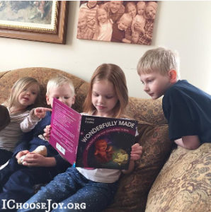 Gena's kids from I Choose Joy with their copy of Wonderfully Made: God's Story of Life from Conception to Birth for kids from ages 5-11.